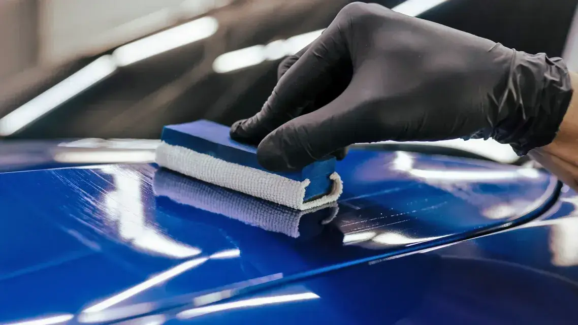 Keramische coating wordt met een applicator op blauwe lak aangebracht
